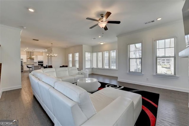 living room featuring ceiling fan with notable chandelier, dark hardwood / wood-style floors, and crown molding