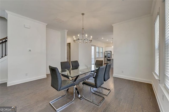 dining room featuring dark wood-type flooring, an inviting chandelier, and ornamental molding