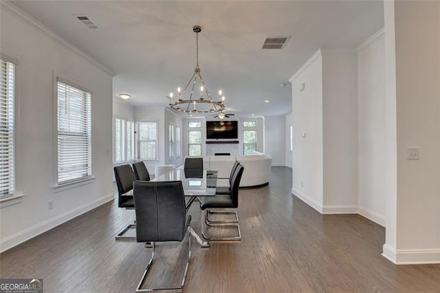 dining area with ceiling fan with notable chandelier, dark hardwood / wood-style floors, and ornamental molding