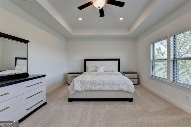 bedroom featuring a tray ceiling, ceiling fan, and light colored carpet