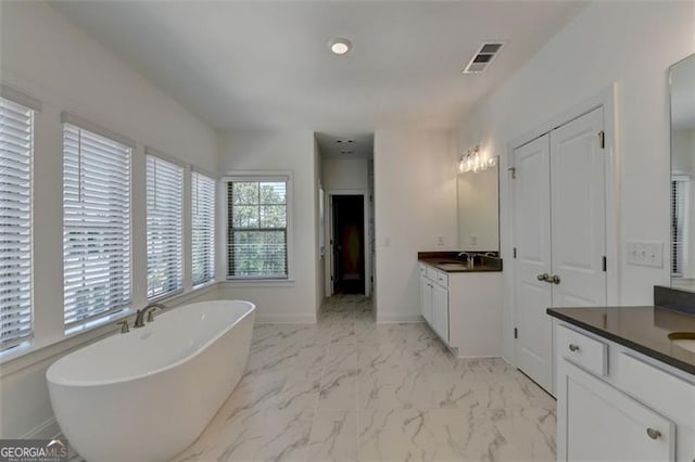 bathroom with vanity and a tub