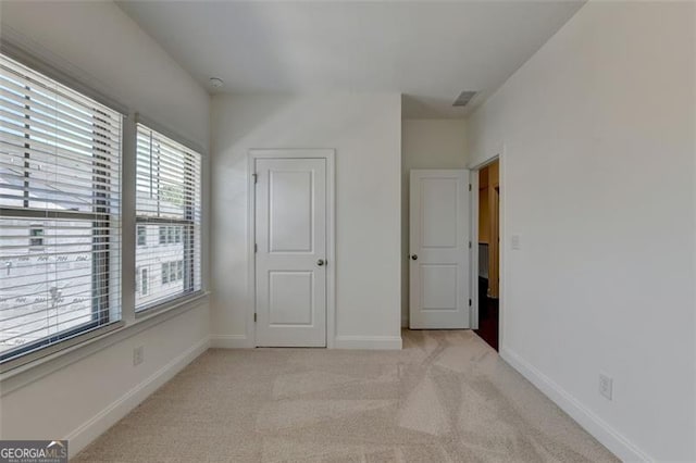 unfurnished bedroom featuring light colored carpet