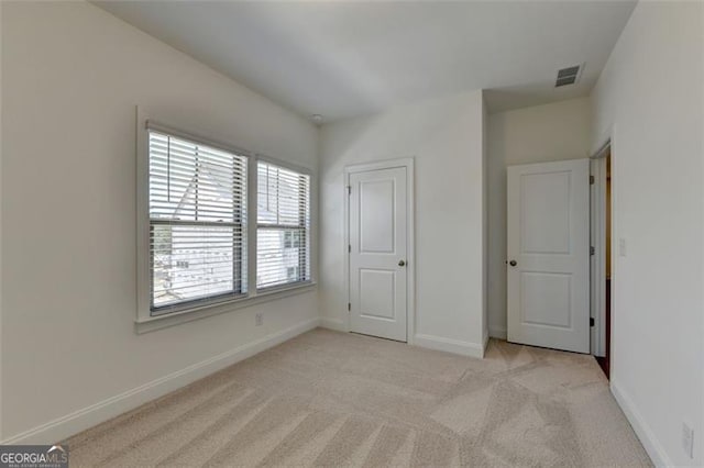 unfurnished bedroom with light colored carpet