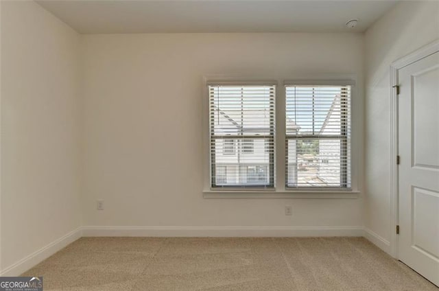 spare room featuring light carpet