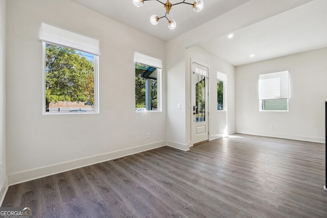 unfurnished room featuring visible vents, baseboards, recessed lighting, an inviting chandelier, and dark wood-style floors