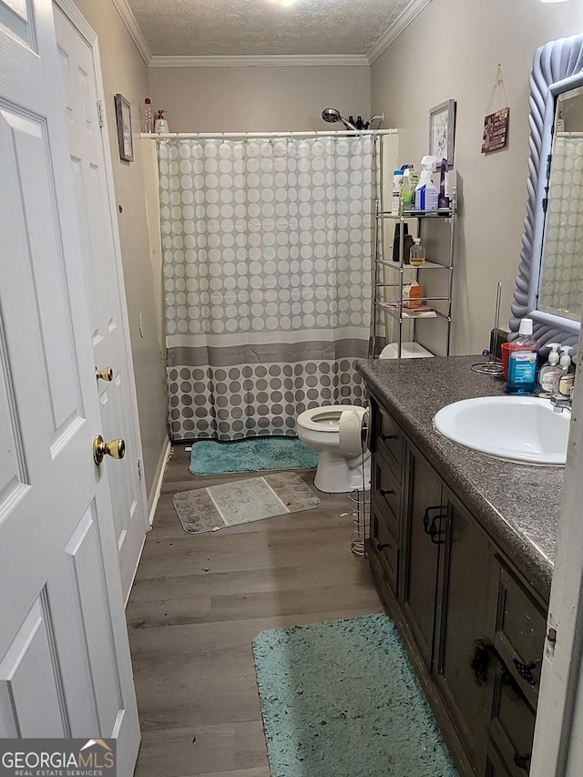 bathroom featuring vanity, hardwood / wood-style flooring, walk in shower, and toilet