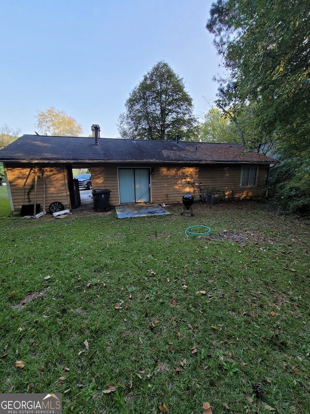 rear view of property featuring a patio and a lawn