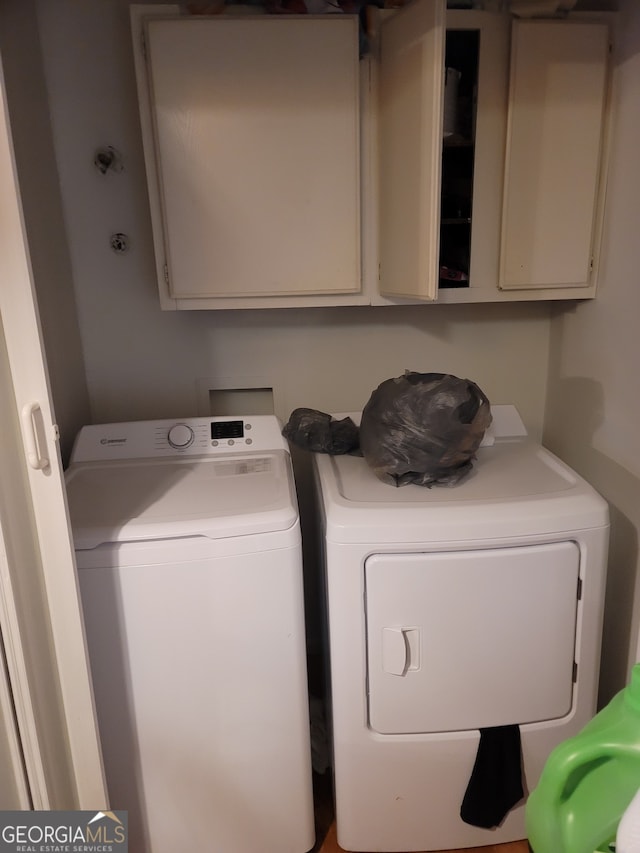 laundry room featuring independent washer and dryer and cabinets