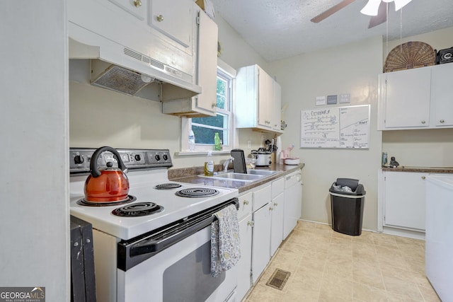 kitchen with white cabinets, white electric stove, and a textured ceiling