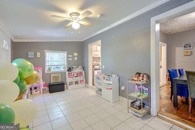 rec room featuring ceiling fan, crown molding, and light tile patterned floors