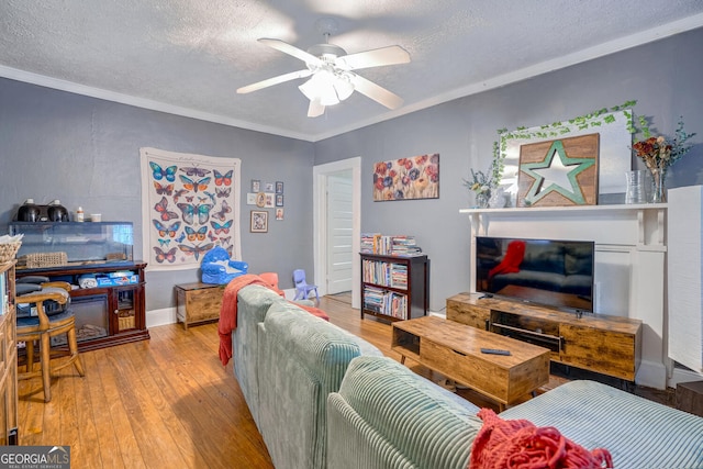 living room with crown molding, light hardwood / wood-style flooring, a textured ceiling, and ceiling fan