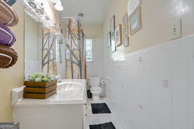 bathroom featuring tile walls, vanity, toilet, and tile patterned flooring