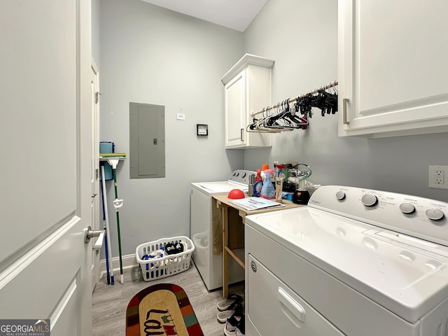 laundry room featuring cabinets, separate washer and dryer, electric panel, and light hardwood / wood-style flooring