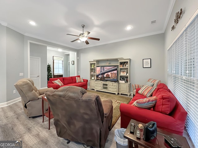 living room with hardwood / wood-style flooring, ceiling fan, and ornamental molding