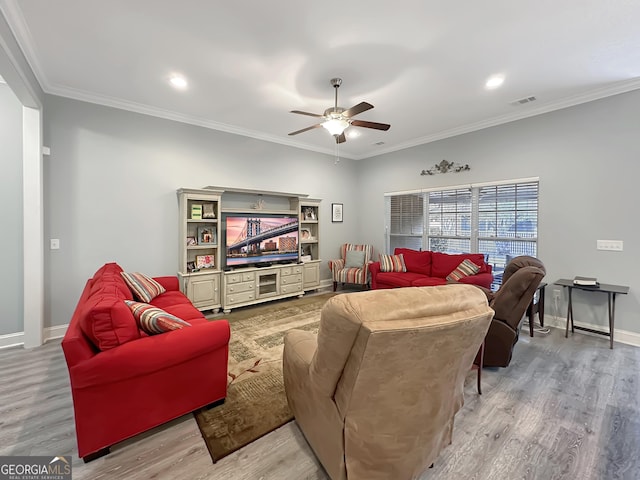 living room featuring crown molding, light hardwood / wood-style floors, and ceiling fan