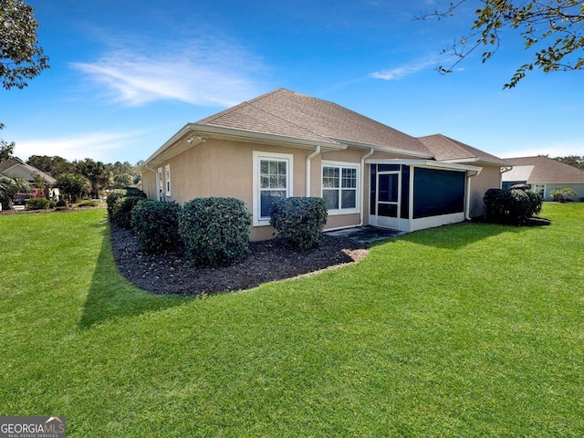 rear view of property with a sunroom and a lawn