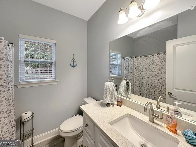 bathroom featuring vanity, plenty of natural light, and toilet