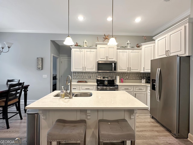 kitchen with appliances with stainless steel finishes, sink, hanging light fixtures, and backsplash