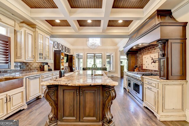 kitchen featuring decorative backsplash, ornamental molding, dark hardwood / wood-style floors, range with two ovens, and a center island