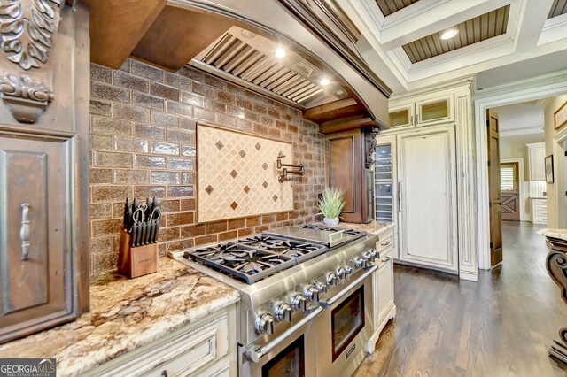 kitchen featuring custom exhaust hood, dark wood-type flooring, crown molding, light stone counters, and double oven range