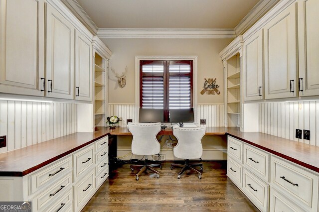 office area with built in desk, crown molding, and dark hardwood / wood-style flooring