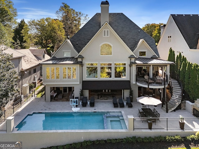 rear view of property with an outdoor hangout area, a patio, and a pool with hot tub