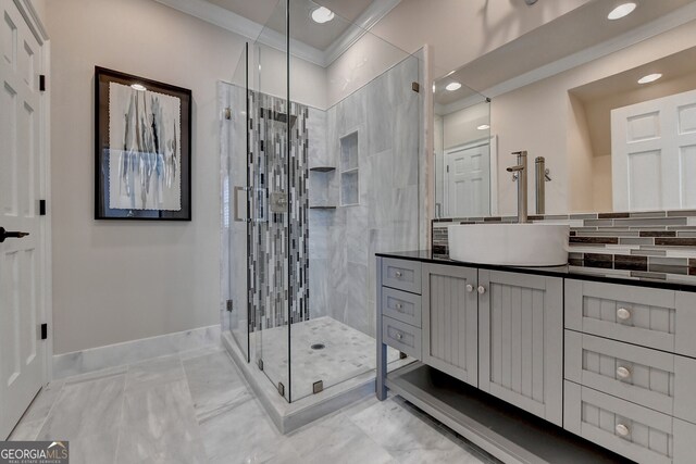 bathroom featuring vanity, ornamental molding, tasteful backsplash, and a shower with shower door