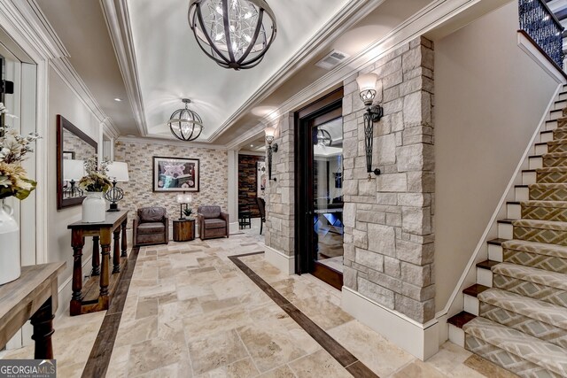 hallway featuring a notable chandelier, ornamental molding, and a tray ceiling