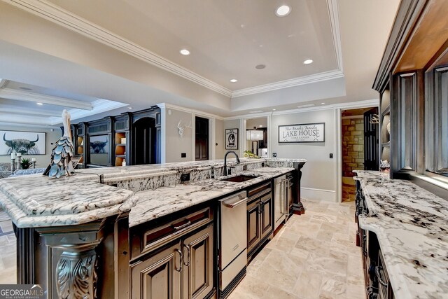 kitchen with a spacious island, light stone countertops, and sink