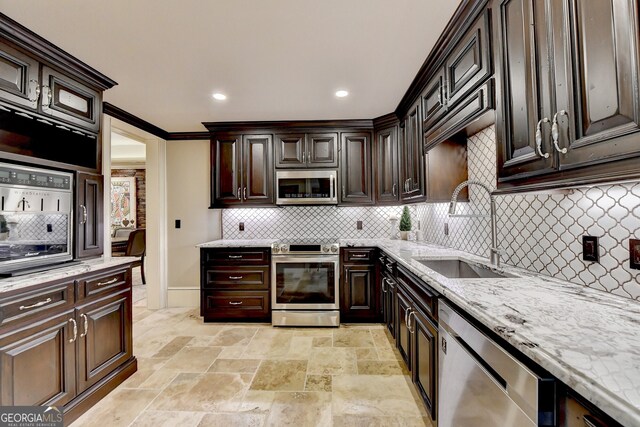 kitchen with appliances with stainless steel finishes, sink, ornamental molding, dark brown cabinetry, and decorative backsplash