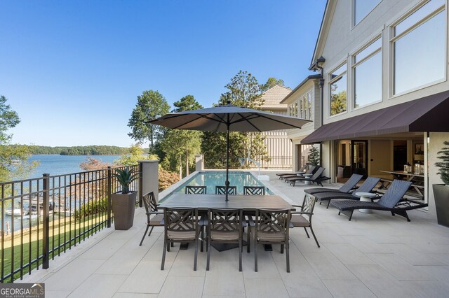 view of patio featuring a water view and a fenced in pool