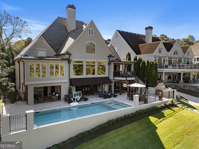 rear view of house with a yard, a patio area, a balcony, and outdoor lounge area