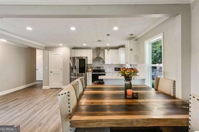 dining area featuring ornamental molding and light hardwood / wood-style flooring