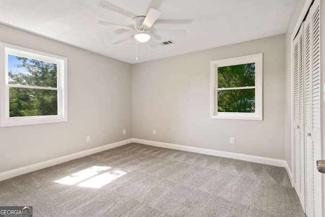 unfurnished bedroom with a closet, carpet flooring, and ceiling fan