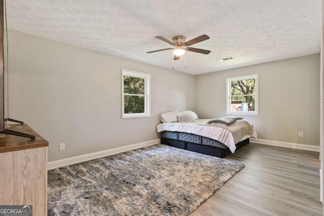 bedroom featuring a textured ceiling, hardwood / wood-style flooring, and ceiling fan