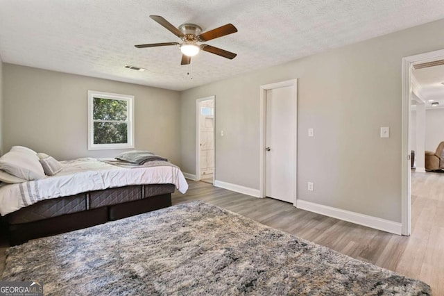 bedroom featuring ceiling fan, hardwood / wood-style flooring, and a textured ceiling