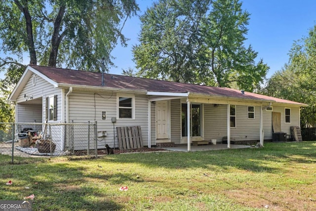 rear view of house featuring a patio, a lawn, and central AC unit