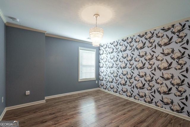 spare room with crown molding, a chandelier, and dark wood-type flooring