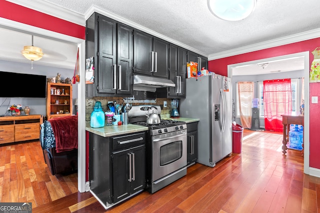 kitchen featuring ornamental molding, stainless steel appliances, wood-type flooring, and backsplash