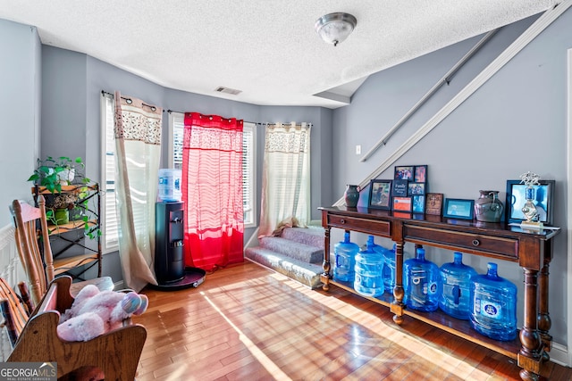 bedroom with hardwood / wood-style floors and a textured ceiling