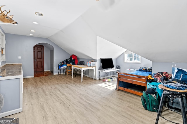 bedroom with lofted ceiling and light wood-type flooring