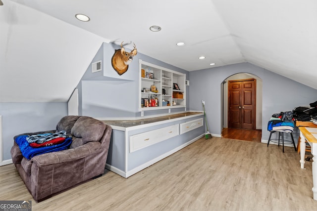 sitting room featuring light hardwood / wood-style floors, lofted ceiling, and built in features