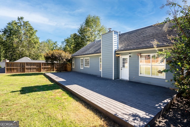 rear view of house with a wooden deck and a yard