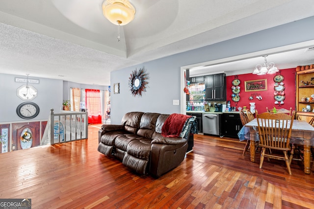 living room with a notable chandelier, a textured ceiling, and hardwood / wood-style floors