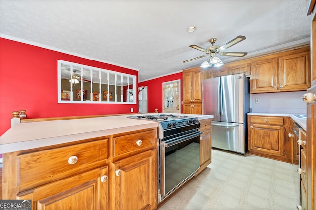 kitchen with black gas stove, ornamental molding, a textured ceiling, stainless steel refrigerator, and ceiling fan