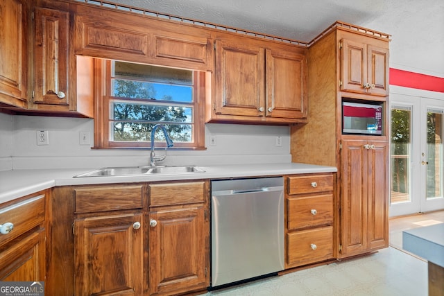 kitchen featuring french doors, dishwasher, sink, and a textured ceiling