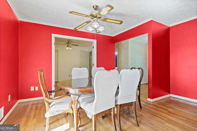 dining room with ceiling fan, a textured ceiling, wood-type flooring, and ornamental molding