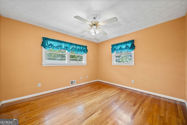 unfurnished room with ceiling fan, a textured ceiling, and hardwood / wood-style floors