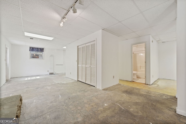 spare room with a drop ceiling and concrete floors