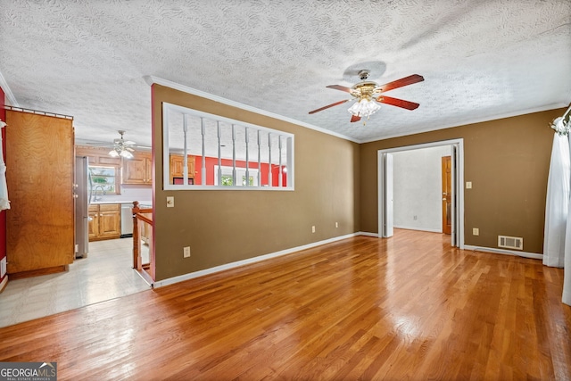 empty room with ornamental molding, light hardwood / wood-style flooring, a textured ceiling, and ceiling fan